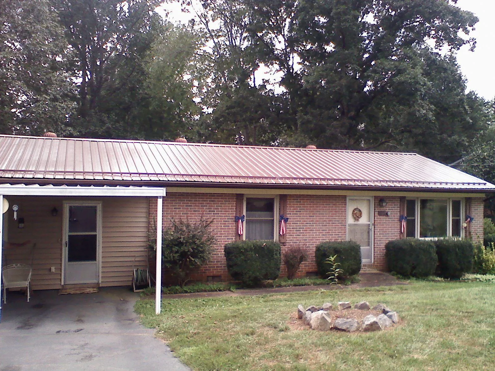 Bronze metal roof and carport on a brick ranch home — Roof Repair work by our crew in Gilman