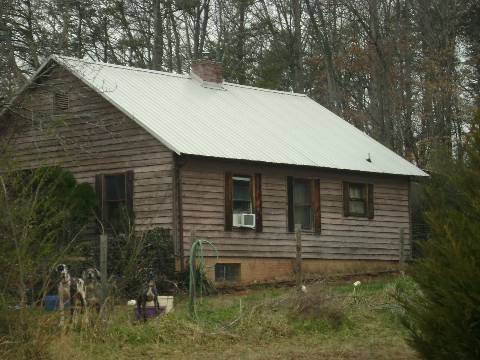 White metal roof on an old wood sided farmhouse, from a Metal Roof Installation job in Gilman